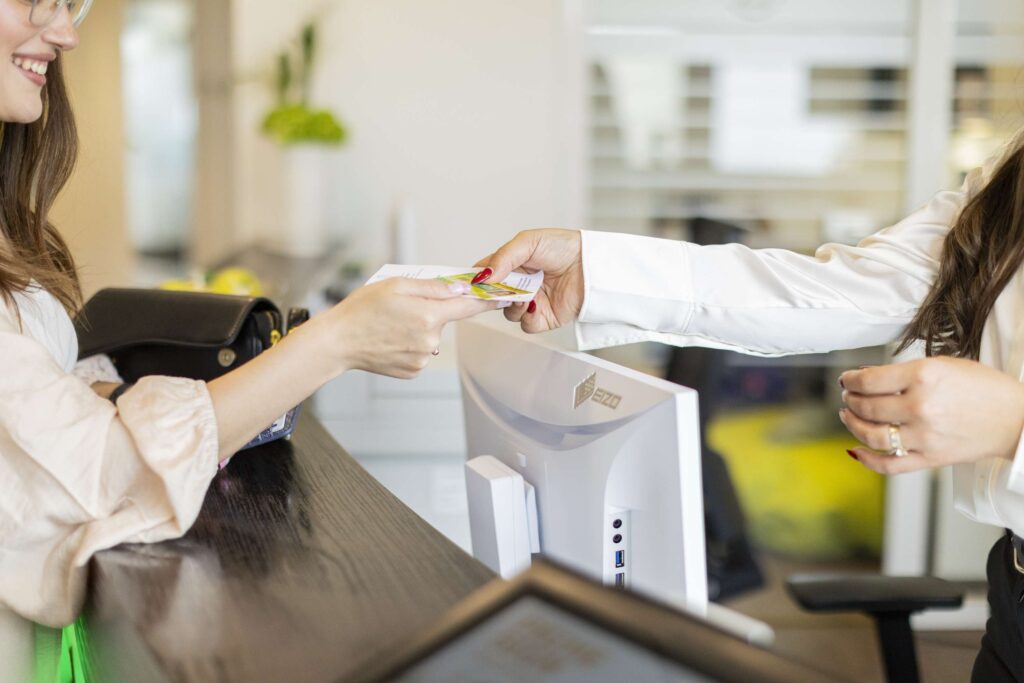 Empfangsdame Gibt Einen Termin An Der Rezeption Der Zahnarztpraxis Weiter.